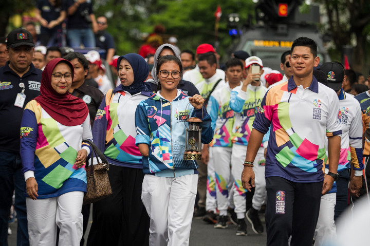 Atlet Paragames, Nanda Mei Sholihah (tengah) bersama Ketua INAPGOC, Raja Sapta Oktohari (kanan) membawa lentera api pada Pawai Api Obor Asian Para Games 2018 di Solo, Jawa Tengah.