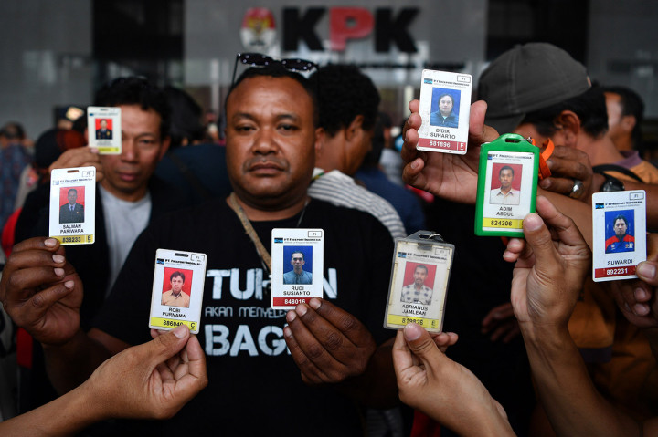 Para korban PHK PT Freeport Indonesia menunjukkan kartu anggota perusahaan saat mendatangi gedung KPK, Jakarta.