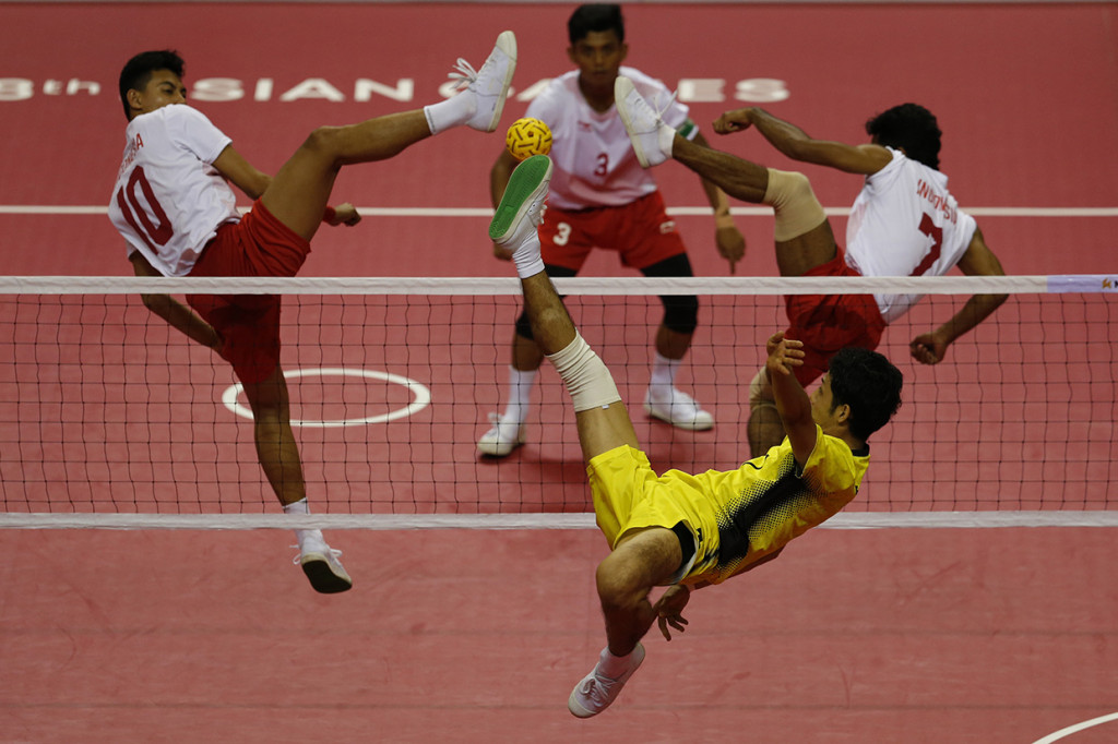 Pemain sepak takraw Jepan Yuki Sato (tengah) melakukan tendangan dan dihadang pemain Indonesia Rizky Abdul Rahan Pago (kiri atas) dan Saiful Rijal pada pertandingan final quadrant putra sepak takraw Asian Games 2018 di GOR Ranau, Jakabaring Sport City (JSC), Palembang, Sumatera Selatan, Sabtu (1/9). Antara Foto/INASGOC/Ferdy Siregar