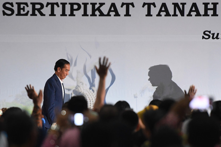 Presiden Joko Widodo (kiri) menaiki panggung untuk memberikan arahan saat penyerahan sertifikat tanah untuk rakyat di Surabaya. Antara Foto/Zabur Karuru
