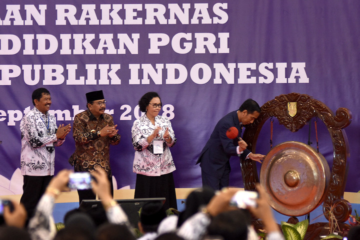 Presiden Joko Widodo (kanan) didampingi Gubernur Jawa Timur Soekarwo (kedua kiri), Rektor Universitas PGRI Surabaya Djoko Adi Waludjo (kiri) dan Ketua Pengurus Besar PGRI Unifah Rosyidi (kedua kanan) memukul gong ketika membuka rapat kerja nasional (rakernas) lembaga pendidikan PGRI usai memberikan kuliah umum wawasan kebangsaan di Universitas PGRI Adi Buana Surabaya, Jawa Tmur. Antara Foto/M Risyal Hidayat