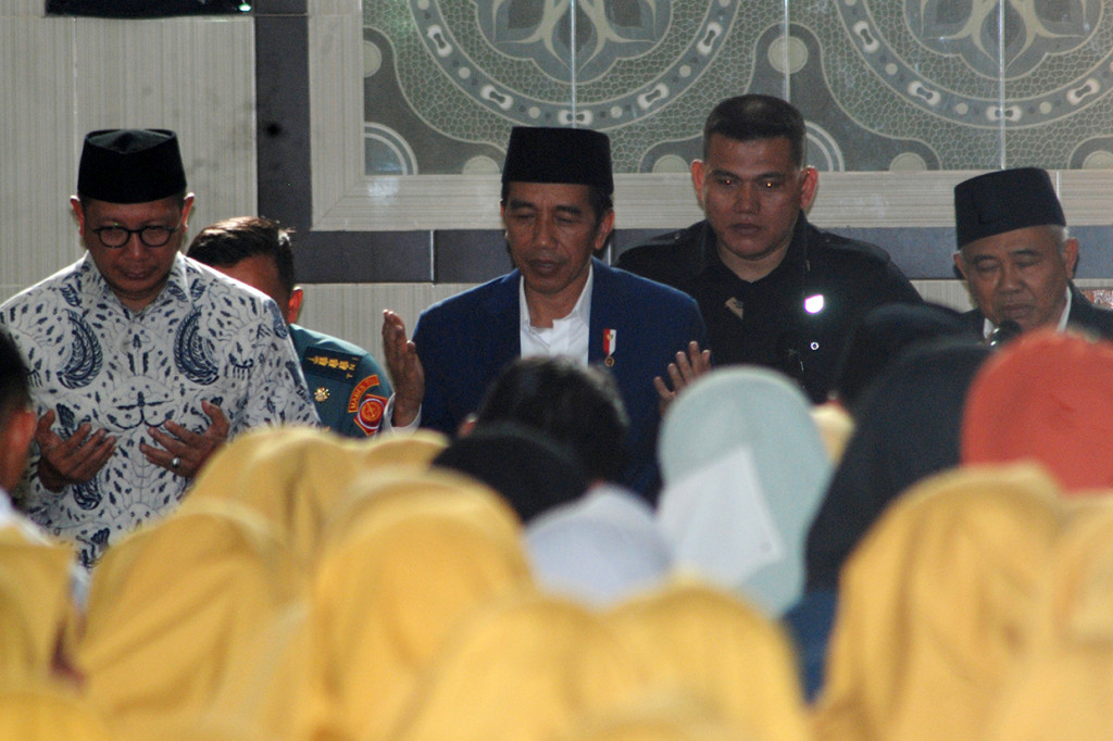 Presiden Joko Widodo (tengah), pengasuh Pondok Pesantren Amanatul Ummah, KH Asep Saifuddin Chalim (kanan), Menteri Agama Lukman Hakim Saifuddin (kiri) berdoa bersama saat berkunjung di Pacet, Mojokerto, Jawa Timur. Antara Foto/Syaiful Arif