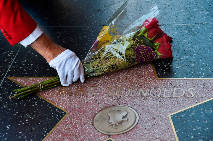 Seorang penggemar meletakkan karangan bunga di bintang milik aktor Burt Reynolds di Hollywood walk of fame, Hollywood, California, Kamis, 6 September 2018 waktu setempat.