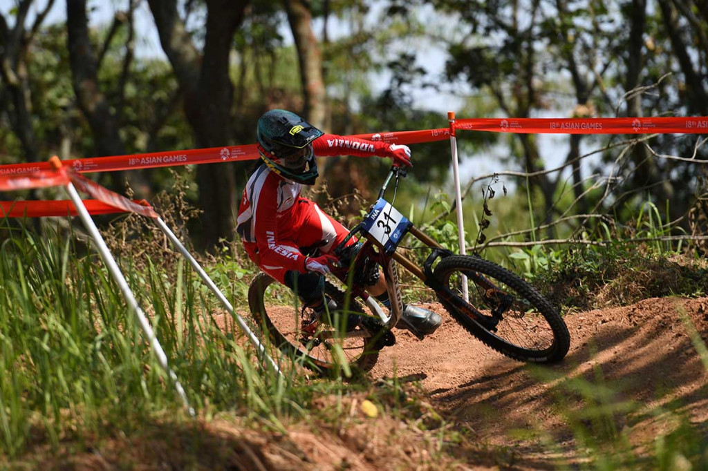 Perjuangan atlet sepeda gunung Indonesia Tiara Andini Prastika saat berjuang merebut medali emas cabang run women elite downhill di Subang, Jabar, 20 Agustus. INASGOC/Antara Foto/Aji Wisnu Novianto