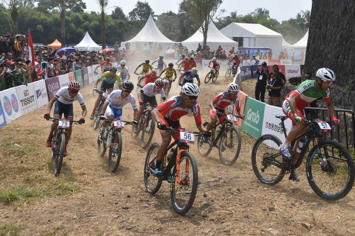 Sejumlah atlet sepeda gunung memacu sepedanya pada nomor run men elite downhill. Khoiful menyumbang emas untuk Indonesia. AFP Photo/Timur Matahari