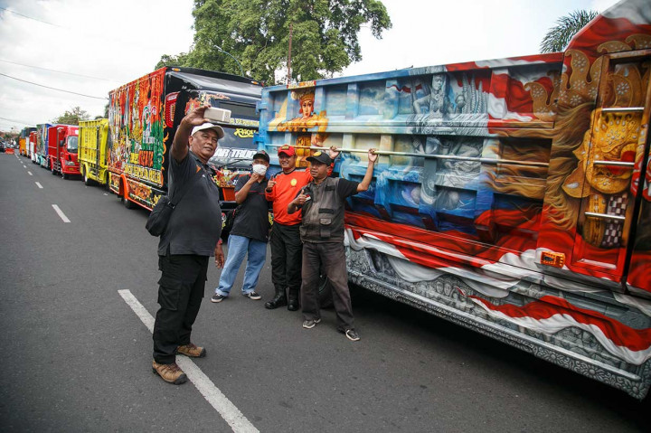 Warga berfoto di depan deretan truk modifikasi saat acara parade keliling Kota Yogyakarta sebagai bagian dari penyelenggaraan Jogja Truck Festival 2018. Antara Foto/Hendra Nurdiyansyah