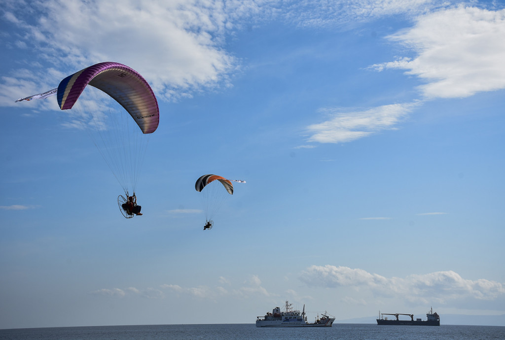 Pilot paramotor melakukan manuver terbang saat pembukaan Sail Moyo Tambora 2018 di Pelabuhan Badas, Sumbawa Besar, Kabupaten Sumbawa, NTB.
