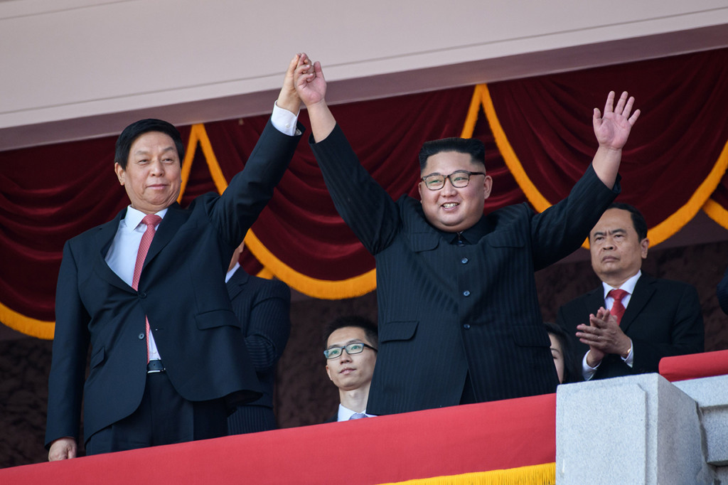 Kim Jong Un bersama Ketua Komite Tetap Kongres Rakyat Nasional (NPC) China, Li Zhanshu melihat pawai militer dari balkon yang menghadap ke Alun-Alun Kim Il-sung, wilayah pusat Pyongyang yang dinamai sesuai kakeknya dan pendiri Korea Utara.