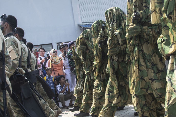 Warga menyaksikan defile prajurit TNI AL dalam upacara peringatan HUT Ke-73 TNI AL di Kompleks Dermaga Pondok Dayung Koarmada I, Tanjung Priok, Jakarta.