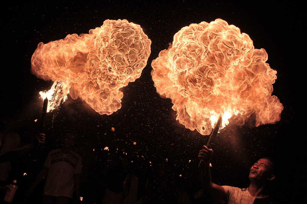 Pelajar menyemburkan bahan bakar minyak ke dekat obor saat mengikuti pawai Tahun Baru Islam di Telanaipura, Jambi, Senin (10/9) malam. Pawai yang diikuti ratusan pelajar, kelompok warga, dan perwakilan instansi tersebut dalam rangka memeriahkan Tahun Baru Islam 1 Muharam 1440 Hijriah. Antara Foto/Wahdi Septiawan