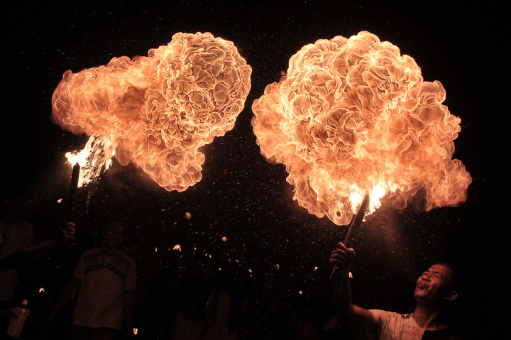 Pelajar menyemburkan bahan bakar minyak ke dekat obor saat mengikuti pawai Tahun Baru Islam di Telanaipura, Jambi, Senin (10/9) malam. Pawai yang diikuti ratusan pelajar, kelompok warga, dan perwakilan instansi tersebut dalam rangka memeriahkan Tahun Baru Islam 1 Muharam 1440 Hijriah. Antara Foto/Wahdi Septiawan