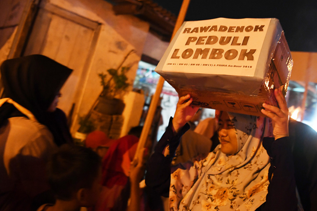 Warga membawa kotak sumbangan gempa Lombok ketika mengikuti pawai menyambut Tahun Baru Islam di Rawadenok, Depok, Jabar, Senin (10/9). Pawai šbor tersebut untuk menyambut Tahun Baru Islam 1 Muharram 1440 Hijriah. Antara Foto/Wahyu Putro A