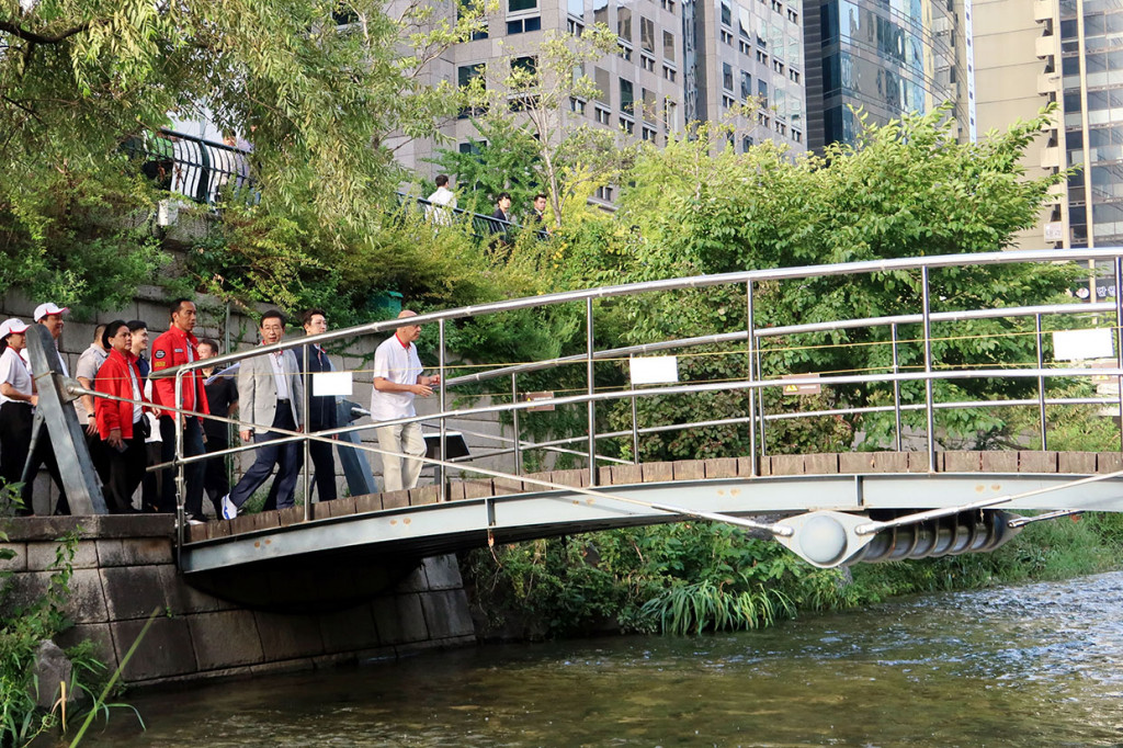 Presiden Joko Widodo (kedua kiri) didampingi Ibu Negara Iriana Joko Widodo (kiri) dan Wali Kota Seoul Won-Soon (ketiga kanan) mengunjungi Sungai Cheonggyecheon di Seoul, Korsel. Kunjungan tersebut merupakan rangkaian kunjungan kenegaraan presiden di Korea Selatan.