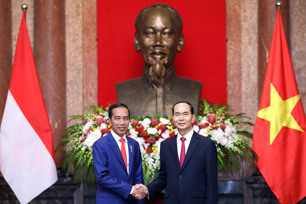 Presiden Joko Widodo bersalaman dengan Presiden Vietnam Tran Dai Quang setelah upacara penyambutan di Istana Kepresidenan, Hanoi, Vietnam (11/9). Afp Photo/Pool/Luong Thai Linh