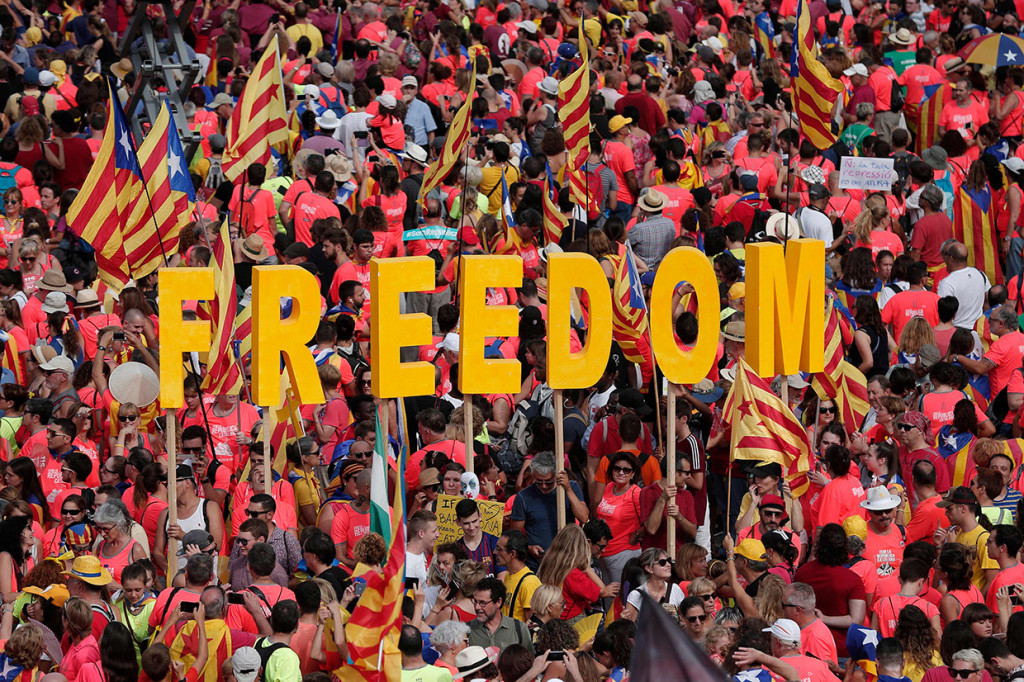 Suara drum dan siulan mewarnai aksi ini. Orang-orang juga melambaikan bendera separatis Catalonia yang didominasi warna merah, kuning dan biru. Afp Photo/Pau Barrena