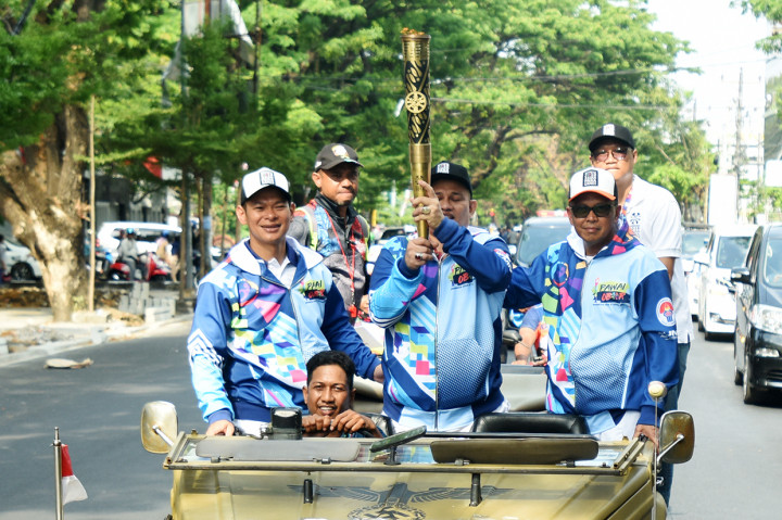 Gubernur Sulsel Nurdin Abdullah (kanan) bersama Ketua Panitia Pelaksana Asian Para Games (Inapgoc) Raja Sapta Oktohari (kiri) dan atlet lempar lembing Bahar Rahman (tengah) membawa obor saat Pawai Obor Asian Para Games di Makassar, Sulawesi Selatan.
