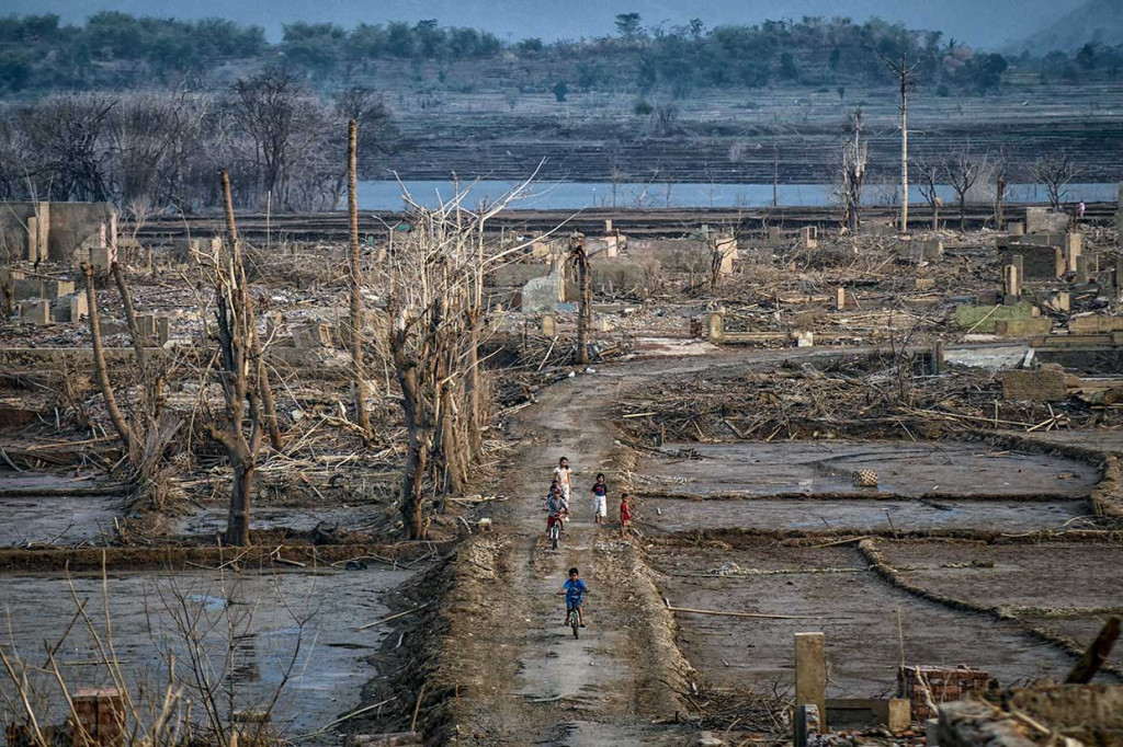 Penyusutan air sejauh 300 meter dari batas air awal di Desa Cipaku, Kecamatan Darmaraja, menjadi daya tarik bagi masyarakat untuk bermain-main di antara puing-puing bangunan tersebut.