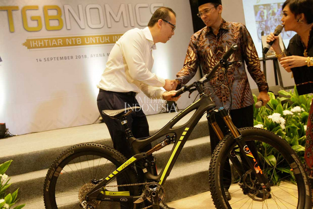 TGB memberikan sepeda seharga Rp 1 miliar yang pernah digunakan Presiden Jokowi saat berkunjung ke Lombok kepada pemenang lelang Jonathan dari Tahir Foundation. MI/Ramdani