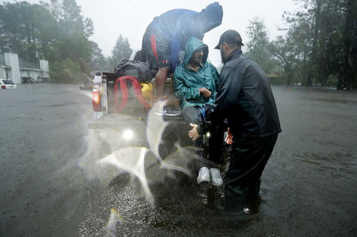 Petugas mengevakuasi warga yang terdampak badai Florence di New Bern, North Carolina. Ratusan orang diselamatkan setelah terperangkap di rumah mereka oleh gelombang badai hingga tiga meter.