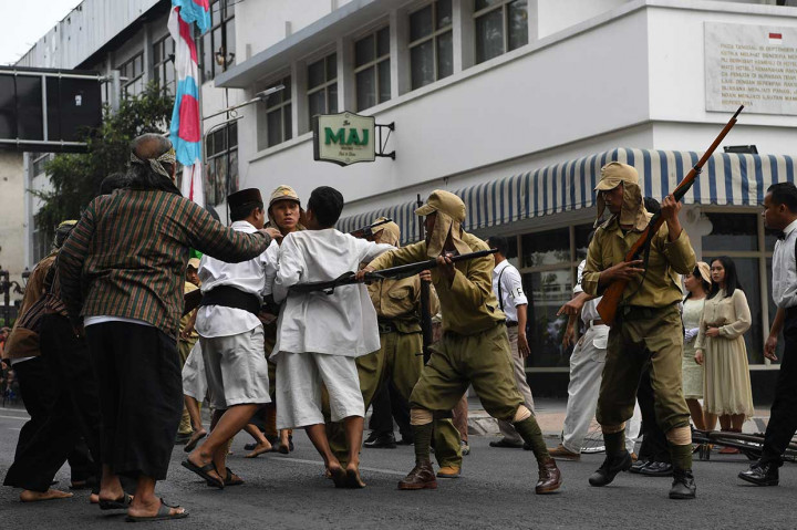 Warga terlibat saling dorong dengan pasukan Jepang saat teatrikal peristiwa perobekan bendera Belanda di Hotel Yamato (sekarang Hotel Majapahit) di Jalan Tunjungan, Surabaya, Jawa Timur, Rabu, 19 September 2018.