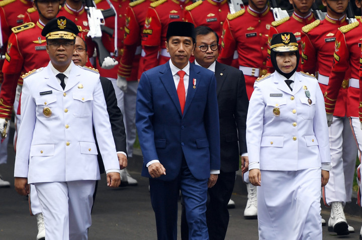 Presiden Joko Widodo (tengah) bersama Gubernur Nusa Tenggara Barat (NTB) terpilih Zulkifliemansyah (kiri) dan Wakil Gubernur terpilih Sitti Rohmi Djalilah (kanan) mengikuti prosesi kirab di Kompleks Istana Kepresidenan, Jakarta.