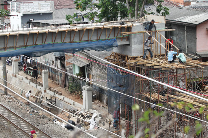Pekerja menyelesaikan proses pembangunan Jembatan Penyeberangan Orang (JPO) di kawasan stasiun Tebet.