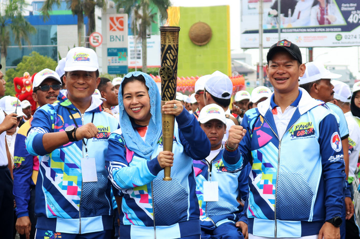 Direktur Wahid Institute Yenny Wahid (tengah) didampingi Ketua Panitia Pelaksana Asian Para Games (Inapgoc) Raja Sapta Oktohari (kanan) dan Kapolda Kalbar Irjen Pol Didi Haryono (kiri), membawa api obor Asian Para Games 2018 di Alun-Alun Sungai Kapuas, Pontianak, Kalbar.