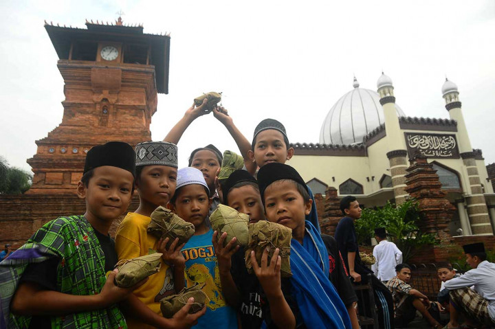 Anak-anak menunjukkan nasi jangkrik yang mereka peroleh.