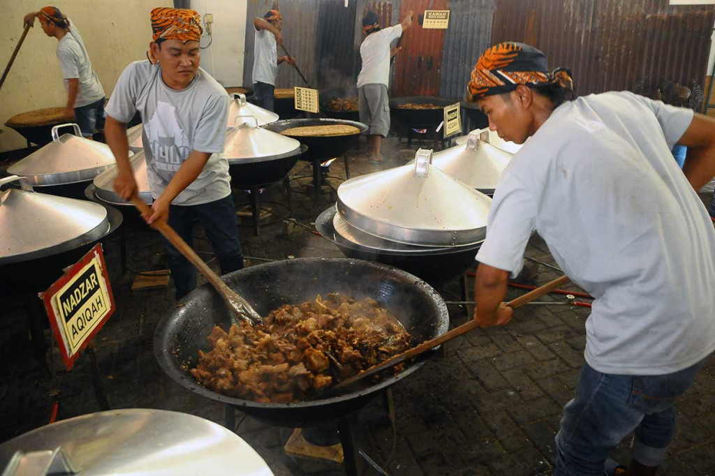 Pekerja memasak daging kerbau sebagai lauk nasi jangkrik dalam  ritual Bukak Luwur Sunan Kudus.