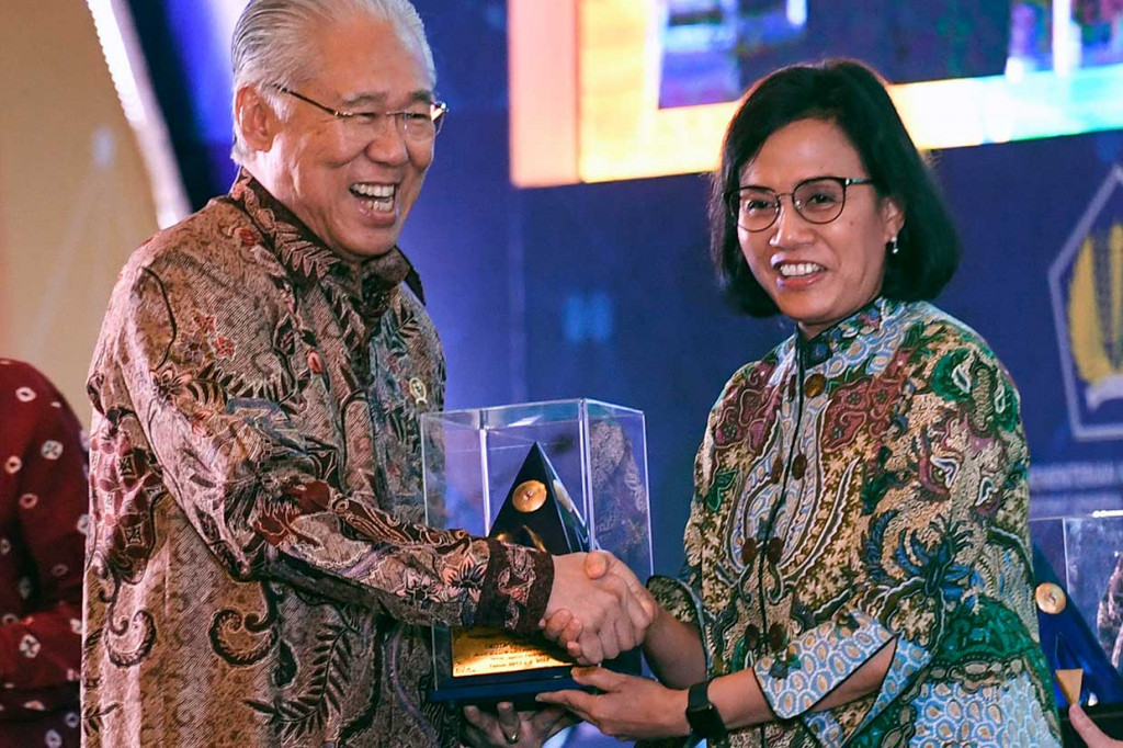 Menteri Keuangan Sri Mulyani (kanan) menyerahkan penghargaan kepada Menteri Perdagangan Enggartiasto Lukita. Pemerintah memberikaan penghargaan untuk 93 entitas kementerian lembaga dan pemerintah daerah provinsi dan kabupaten kota yang mendapatkan opini laporan keuangan wajar tanpa pengecualian (WTP) selama lima tahun (2013-2017) berturut-turut.