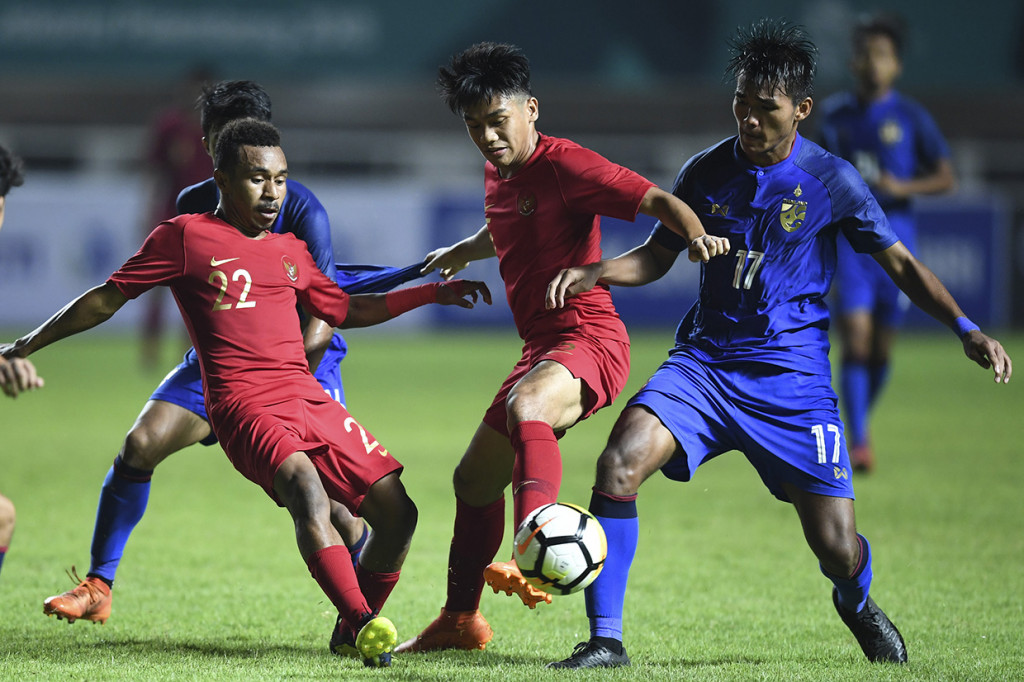 Pesepak bola Timnas U-19 Rivaldo Todd Ferre (kiri) dan Samuel C. Simanjuntak (tengah) berebut bola dengan pesepak bola Thailand U-19 Kritsana Daokrajai (kanan) pada laga PSSI 88th U19 International Tournament di Stadion Pakansari, Cibinong, Bogor.
