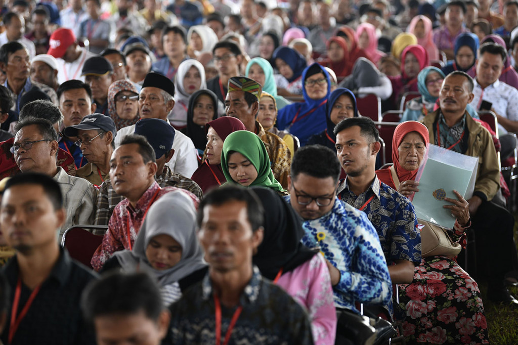Warga memeriksa sertifikat tanah miliknya disela-sela penyerahan Sertifikat Tanah Untuk Rakyat oleh Presiden Joko Widodo di Stadion Pakansari, Bogor, Jawa Barat.

