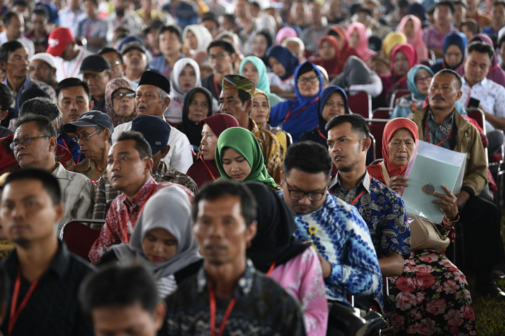 Warga memeriksa sertifikat tanah miliknya disela-sela penyerahan Sertifikat Tanah Untuk Rakyat oleh Presiden Joko Widodo di Stadion Pakansari, Bogor, Jawa Barat.

