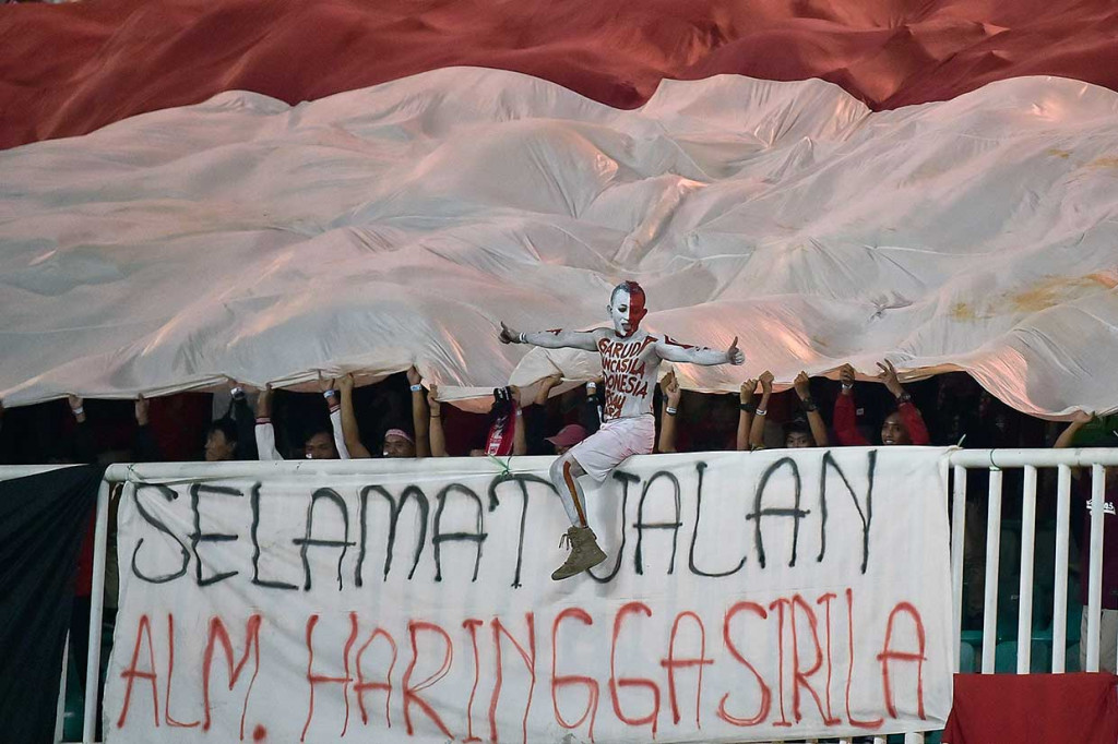 Suporter membentangkan poster bertuliskan 'Selamat Jalan Alm. Haringga Sirila, saat berlangsung pertandingan Timnas U19 Indonesia melawan Tiongkok dalam laga PSSI 88th U19 International Tournament di Stadion Pakansari, Cibinong, Bogor.