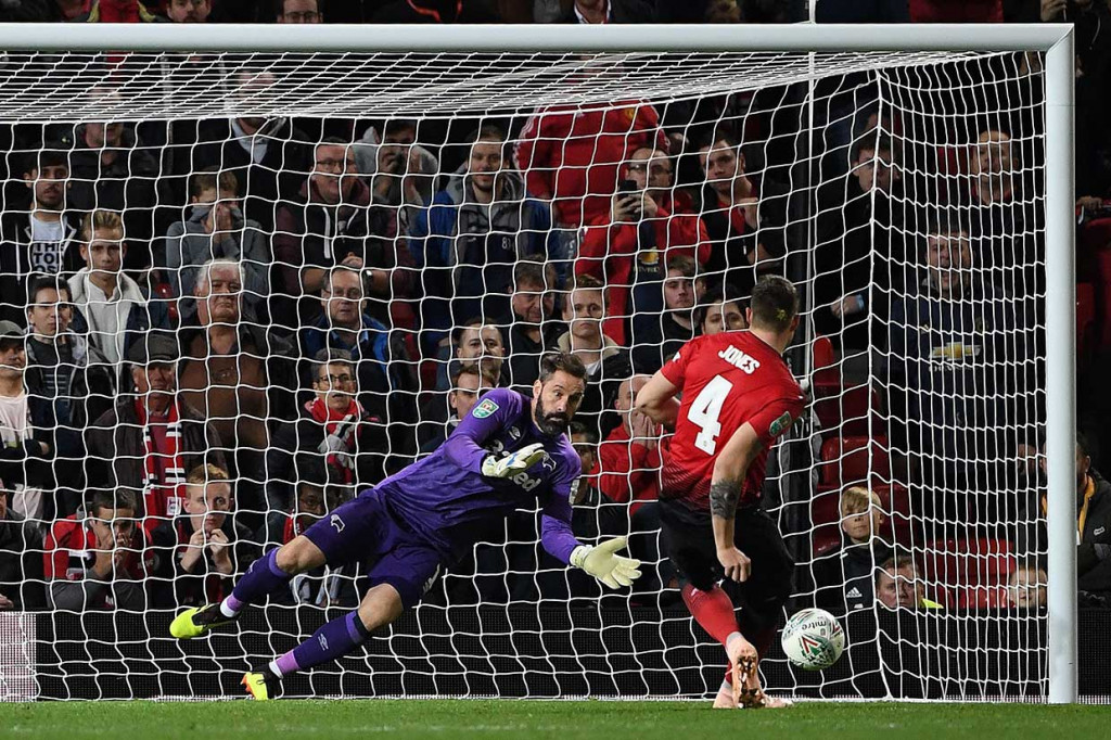 Tembakan bek tengah MU Phil Jones dapat dibaca oleh Scott Carson.