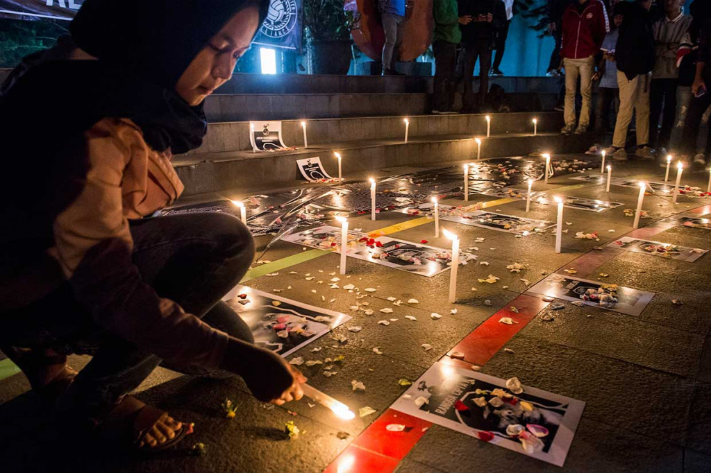 Seorang simpatisan yang tergabung dalam Bandung Supporter Alliance menyalakan lilin untuk korban meninggal karena sepak bola saat aksi solidaritas suporter di Bandung, Jawa Barat, Kamis, 27 September malam.
