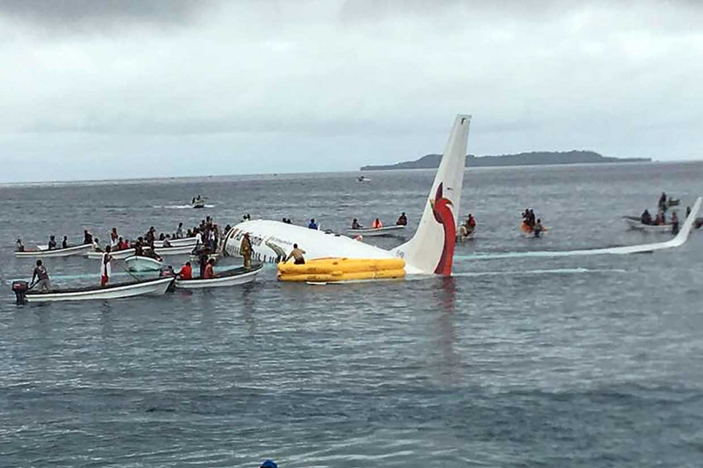 Penduduk dengan perahu berusaha menyelamatkan penumpang dari pesawat Air Niugini yang tercebur ke sebuah laguna di pulau terpencil Weno, di Mikronesia, Jumat 28 September. Air Niugini adalah maskapai nasional Papua Nugini.