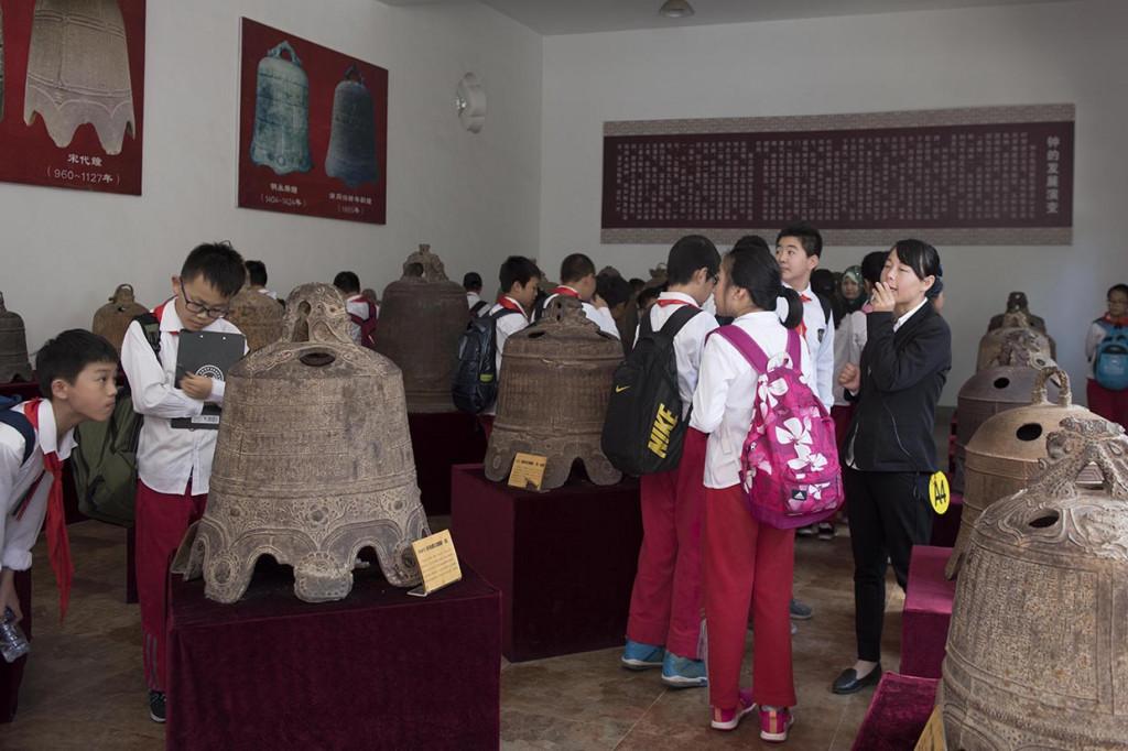 Sejumlah pelajar sekolah dasar mendengarkan penjelasan guru mereka d salah satu ruangan koleksi lonceng lonceng kuno di Museum Guanzhong Folk Art, di Xi'an, Shaanxi.