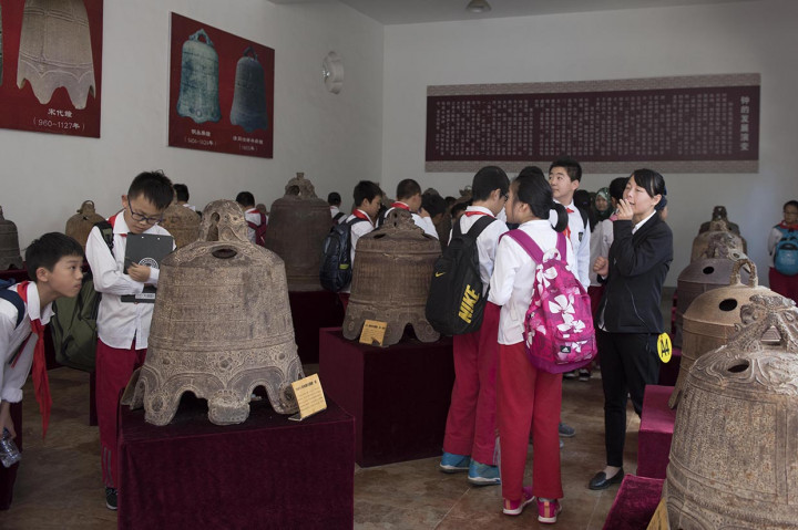 Sejumlah pelajar sekolah dasar mendengarkan penjelasan guru mereka d salah satu ruangan koleksi lonceng lonceng kuno di Museum Guanzhong Folk Art, di Xi'an, Shaanxi.