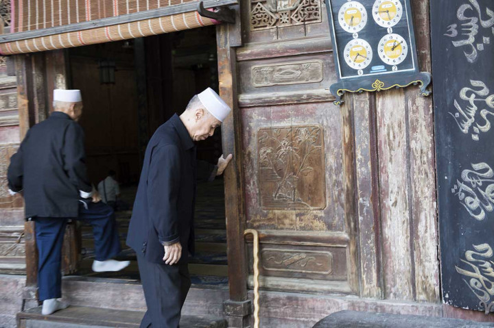 Umat muslim masuk ke dalam masjid saat akan menjalankan ibadah salat di Mesjid Agung, di kawasan komunitas muslim di Xi'an.