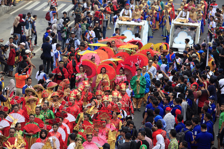 Warga menyambut antusias pawai obor Asian Para Games ketika melintas di Jalan MH Thamrin, Jakarta.