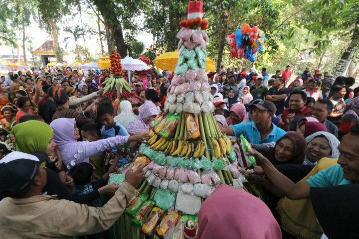 Warga berebut gunungan berisi hasil bumi dan jajanan pasar saat ziarah punden Prabu Anom di Desa Doko, Kediri, Jawa Timur.