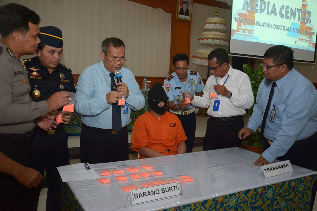 Petugas membekuk tersangka karena terbukti membawa narkoba jenis ekstasi sebanyak 1.887 butir yang disembunyikan di dalam tas saat tiba di terminal kedatangan internasional Bandara Ngurah Rai, Bali, Rabu, 3 Oktober. Antara Foto/Wira Suryantala
