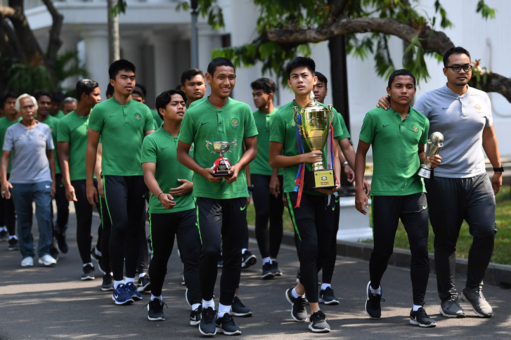 Pemain Timnas U-16 serta tim ofisial berjalan dengan membawa piala sebelum bertemu dengan Presiden Joko Widodo di Istana Merdeka, Jakarta.
