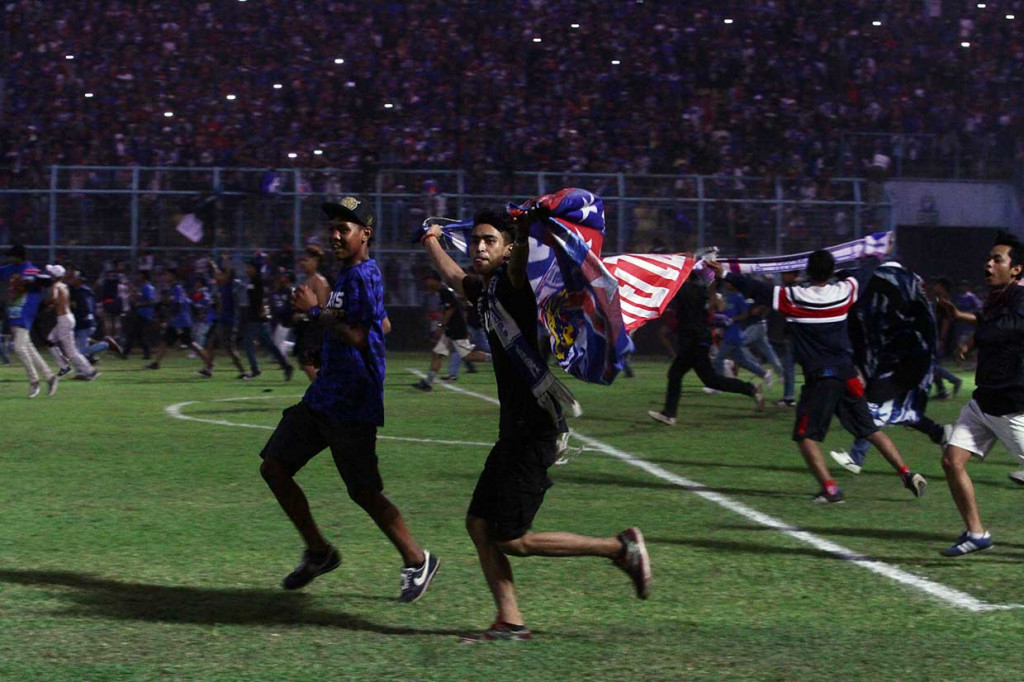 Puluhan oknum suporter Arema FC memasuki lapangan usai tim kesayangannya mengalahkan Persebaya Surabaya 1-0 di Stadion Kanjuruhan, Malang, Jawa Timur, Sabtu, 6 Oktober.