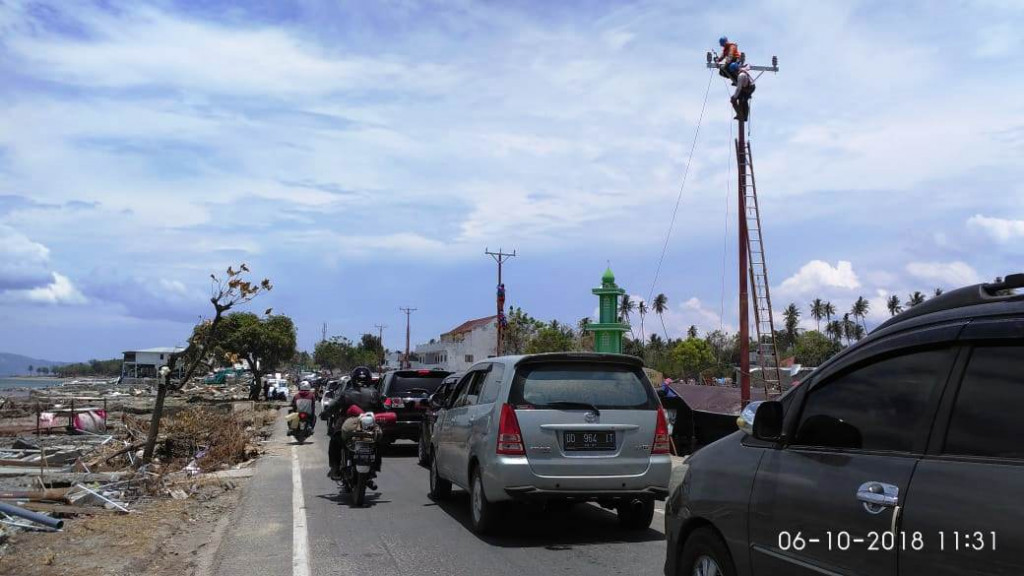 Petugas PLN menyambungkan kembali kabel-kabel yang putus. Jaringan listrik merupakan infrastruktur penting dalam tanggap darurat bencana alam.