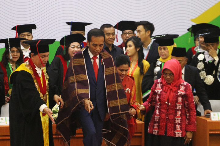 Presiden Joko Widodo  bersama Ibu Negara Iriana Joko Widodo mengenakan ulos yang dipasangkan Rektor Universitas Sumatera Utara (USU) Runtung Sitepu usai menyampaikan orasi, di kampus USU, Medan.