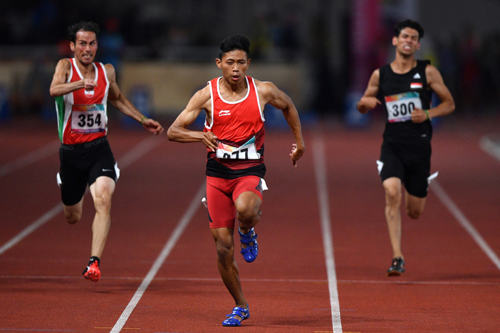 Sprinter Indonesia Sapto Yogo Purnomo (tengah) berlari dalam final 100 meter putra T37 Asian Para Games di Stadion Utama Gelora Bung Karno, Senayan, Jakarta. Sapto berhasil meraih medali emas dengan catatan waktu 11,49 detik.