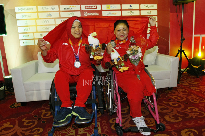 Dua lifter Indonesia Siti Mahmudah (kanan) dan Nurtani Purba menunjukkan medali perak yang mereka raih pada parapowerlifting kelas 79 kg (Siti Mahmudah) dan 73 kg (Nurtani Purba) Asian Para Games 2018 di Balai Sudirman, Jakarta.