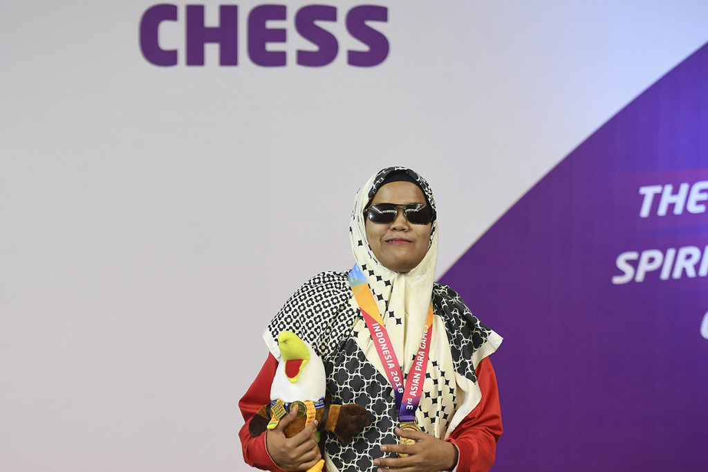 Pecatur putri Indonesia Debi Ariesta berpose seusai menerima medali emas kategori catur standar B1 perorangan putri Asian Para Games 2018 di Cempaka Putih Sports Hall, Jakarta. Antara Foto/Dhemas Reviyanto